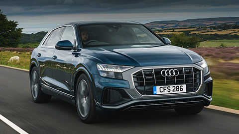 Blue Audi Q8 driving down a country road
