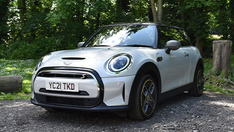 MINI Electric, front quarter shot, parked in front of woodland