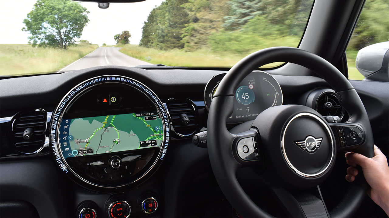 MINI Electric being driven down country road with satellite navigation on