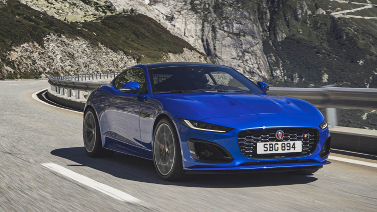 blue jaguar f-type driving in mountains