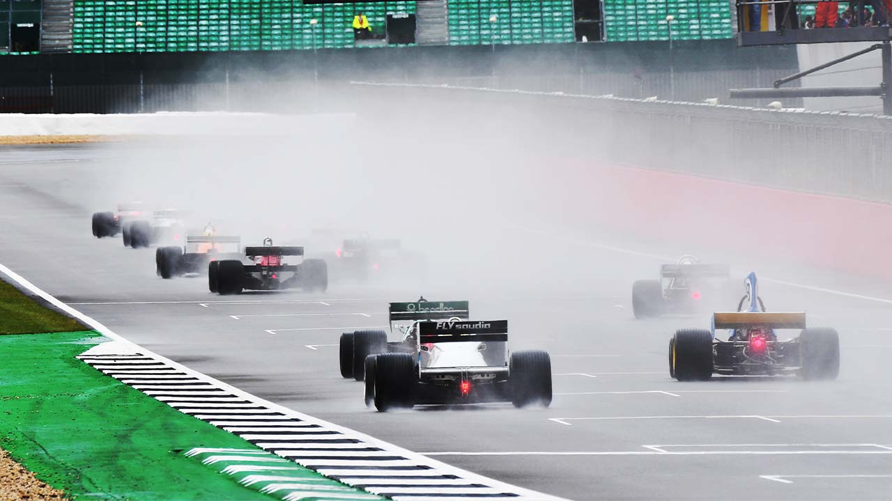 Historic F1 cars racing down Silverstone straight