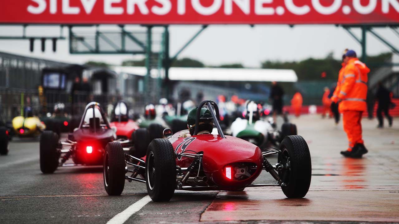 Classic racing cars queueing in the pit lane at Silverstone