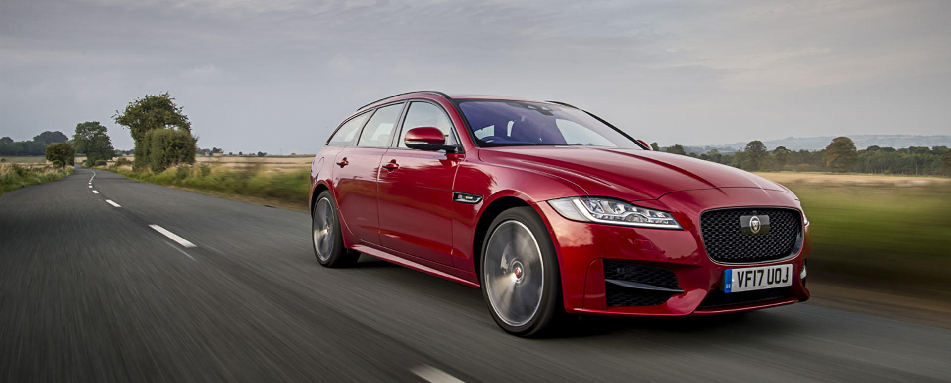 Red Jaguar XF Sportbrake, driving through the countryside