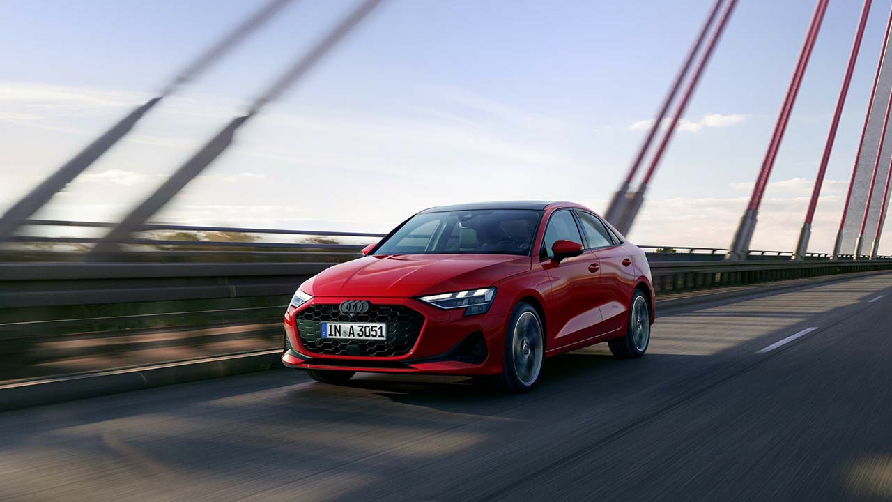 Red Audi A3 Saloon Exterior Front Driving Across a Bridge