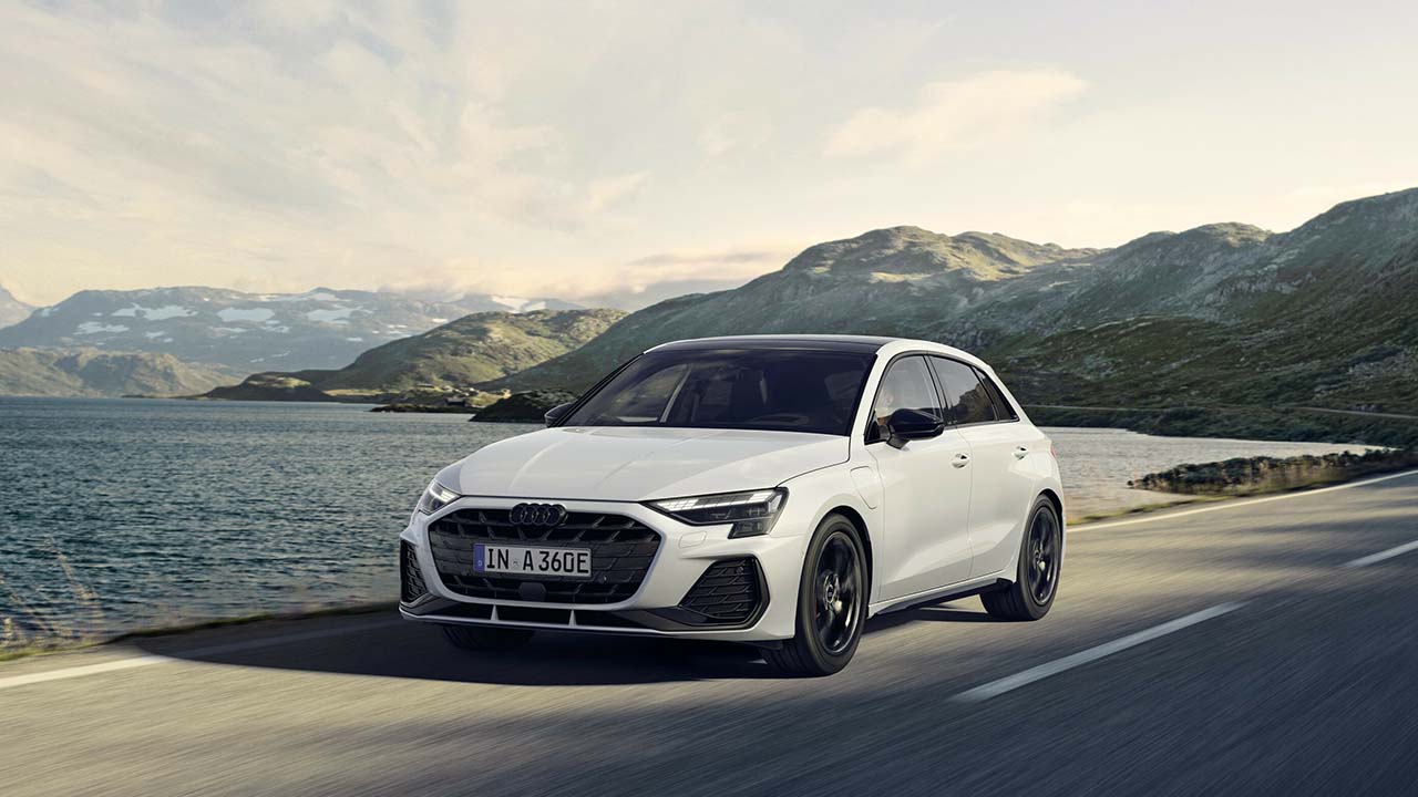 White Audi A3 Sportback Exterior Front Driving Along a Lakeside Road