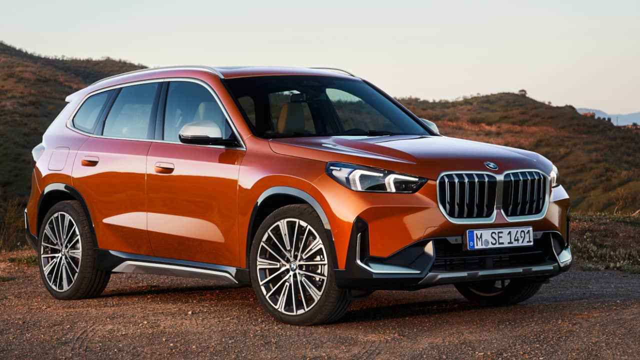 BMW X1 in Orange Parked with Hills in Background