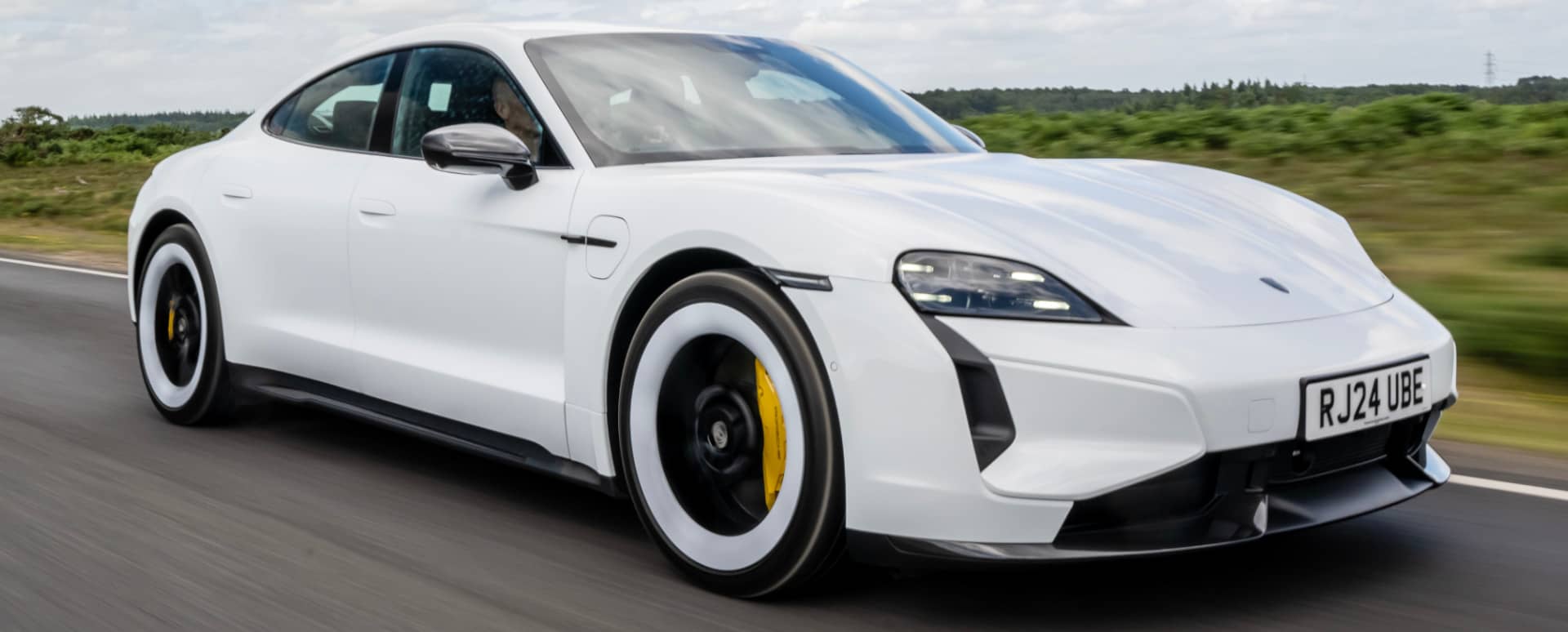 Porsche Taycan Turbo S in White Driving Front Angle