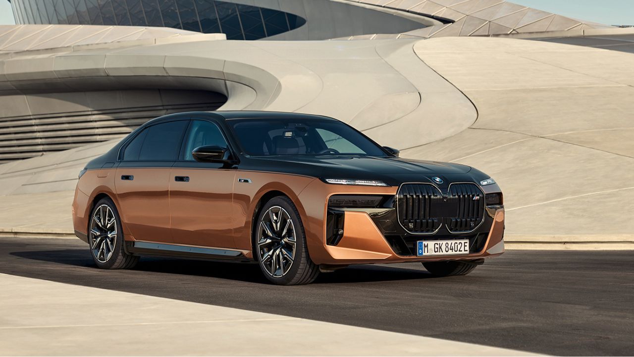 Orange BMW 7 Series parked in front of a beige building