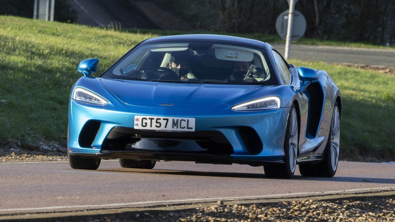 Blue McLaren GT driving in the countryside