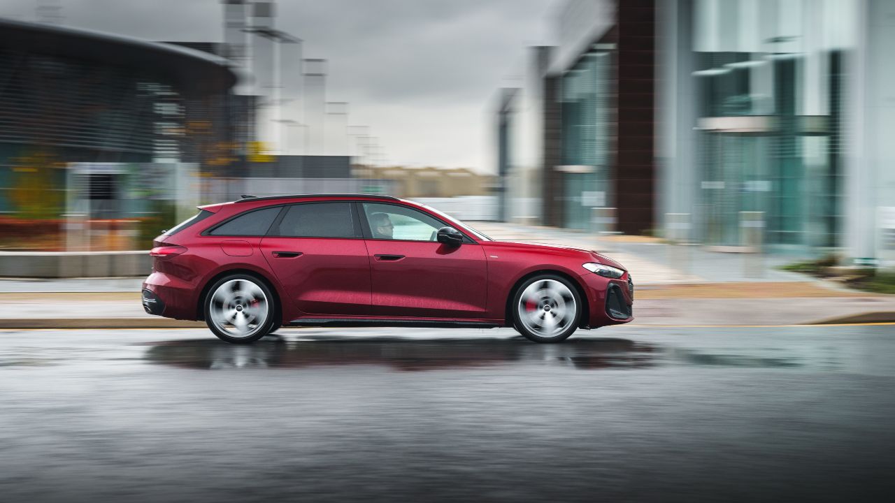 Audi A5 Avant estate driving through city streets, side profile view