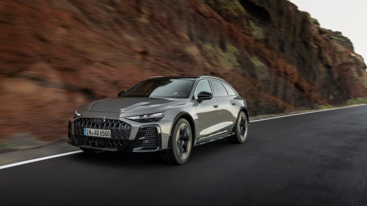 Audi A6 allroad quattro driving on mountain road, front three-quarter view