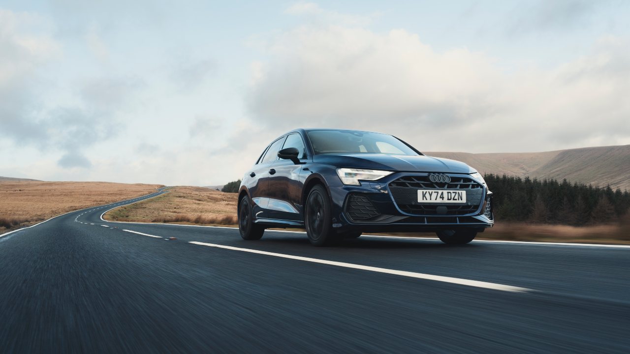 Audi A3 Sportback driving on open countryside road, front three-quarter view