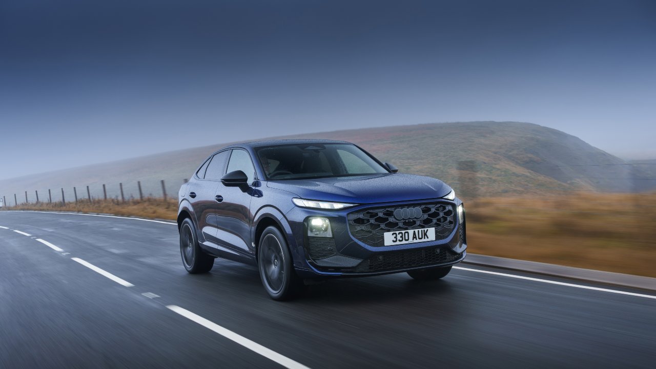 Audi Q3 Sportback driving on wet road through countryside landscape