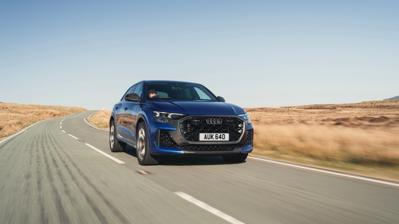 Audi RS Q8 performance SUV driving on rural road, front view