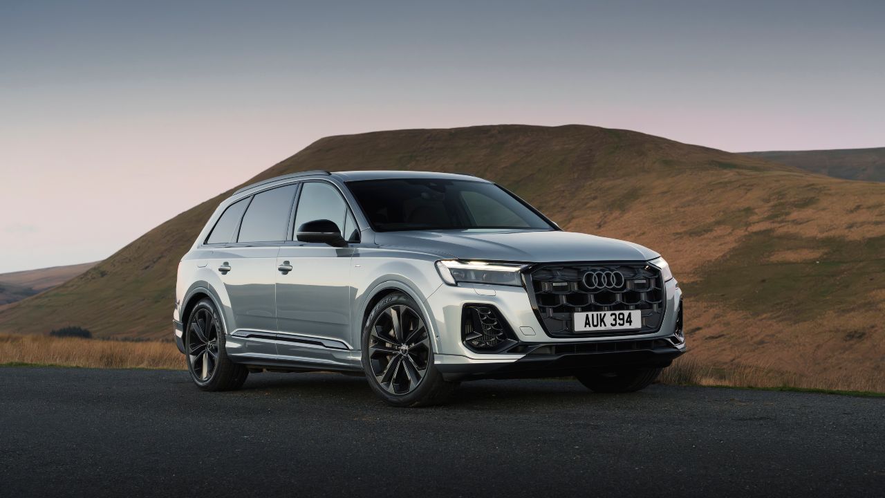Silver Audi Q7 parked on a hillside road, front view