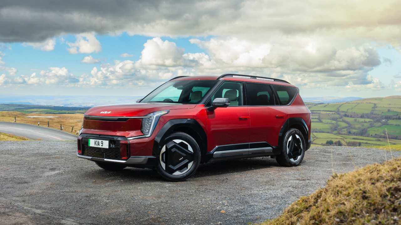 Kia EV9 electric SUV overlooking countryside scenery from a hilltop viewpoint