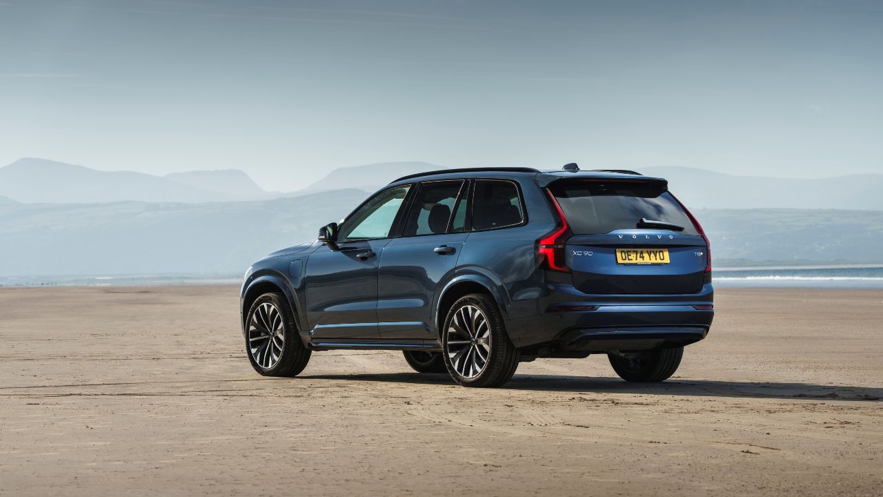 Volvo XC90 plug-in hybrid SUV parked on a coastal landscape with mountains in the background
