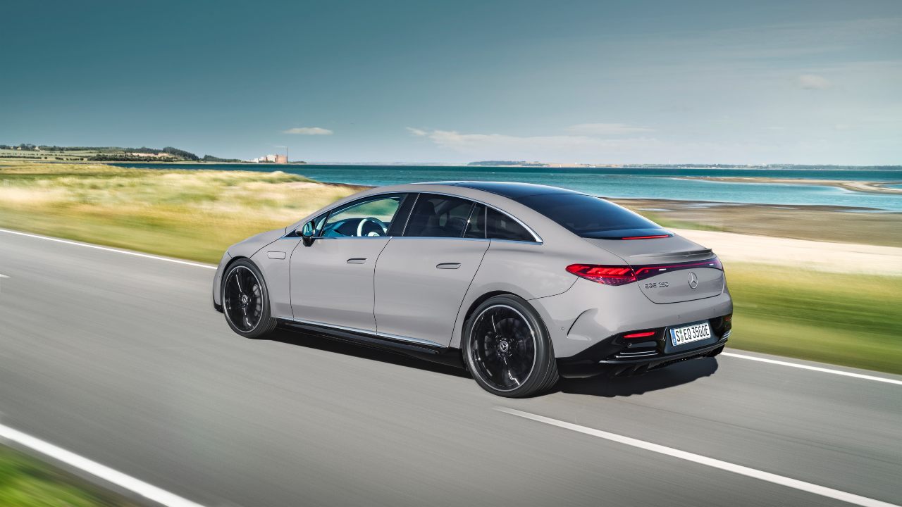 Mercedes-Benz EQE viewed from the rear driving along a scenic coastal road