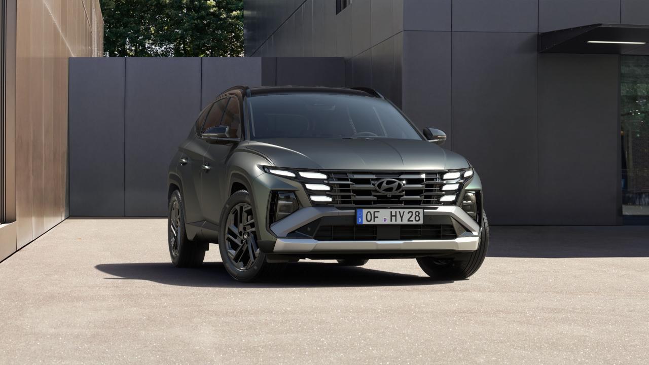 Grey Hyundai Tucson SUV shown from the front, parked outside a modern building