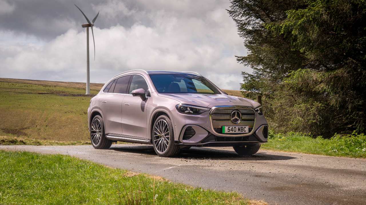 Mercedes-Benz GLC electric SUV parked on countryside road near wind turbine