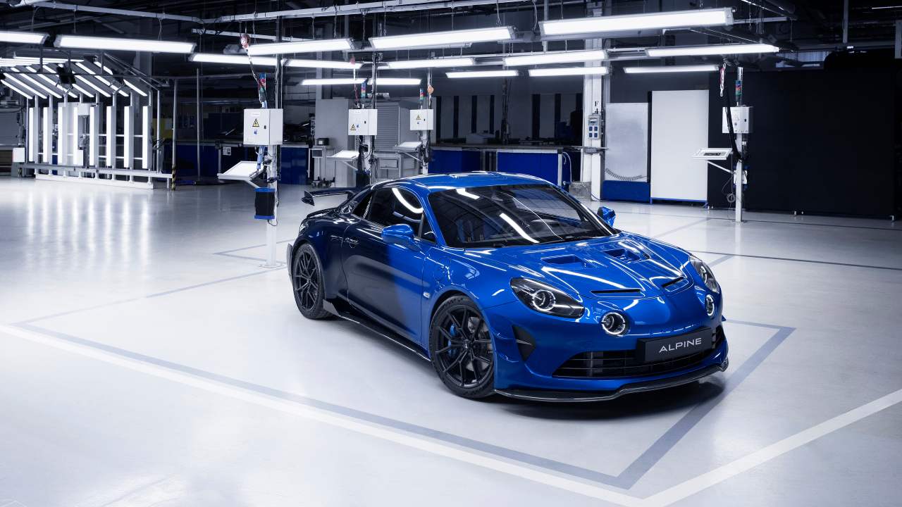Blue Alpine A110 R Ultime limited-edition sports car displayed in a factory showroom setting