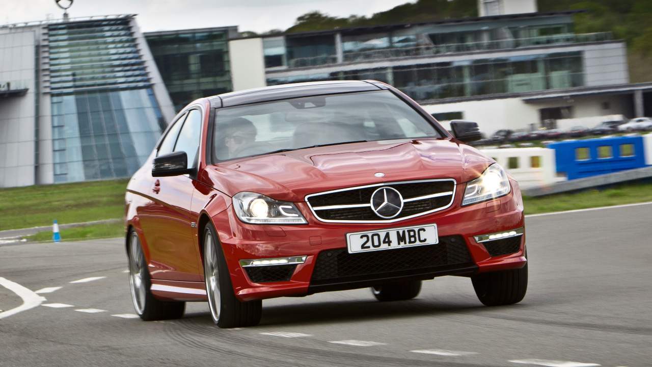 Red Mercedes-AMG C63 performance saloon cornering on a race track