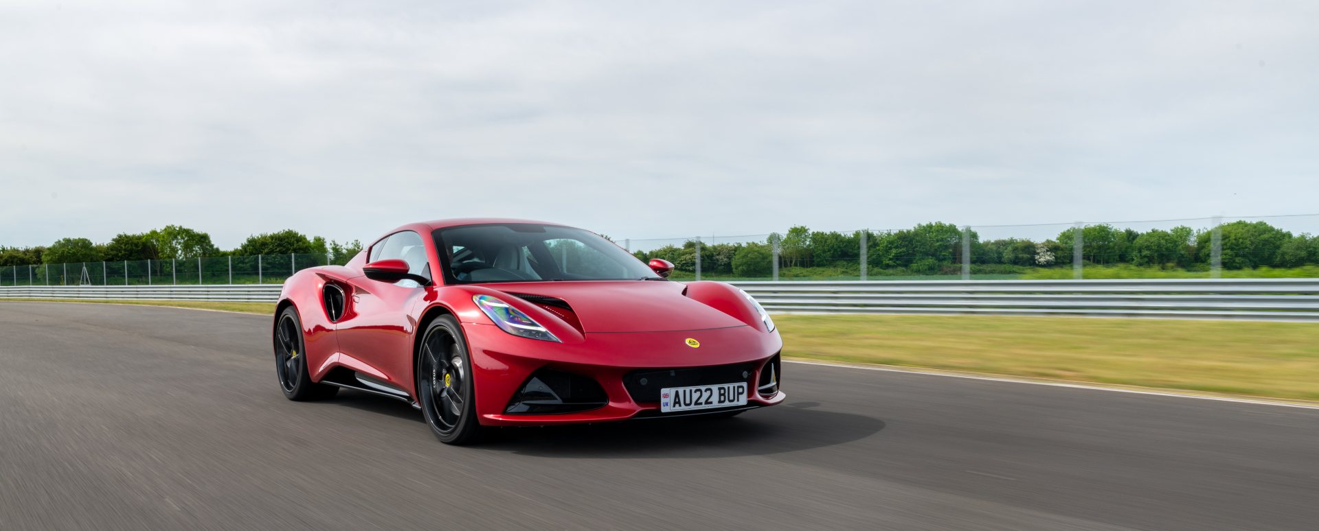 Red Lotus Emira sports car driving on a race track