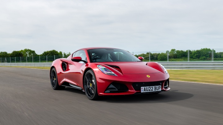 Red Lotus Emira sports car driving on a race track
