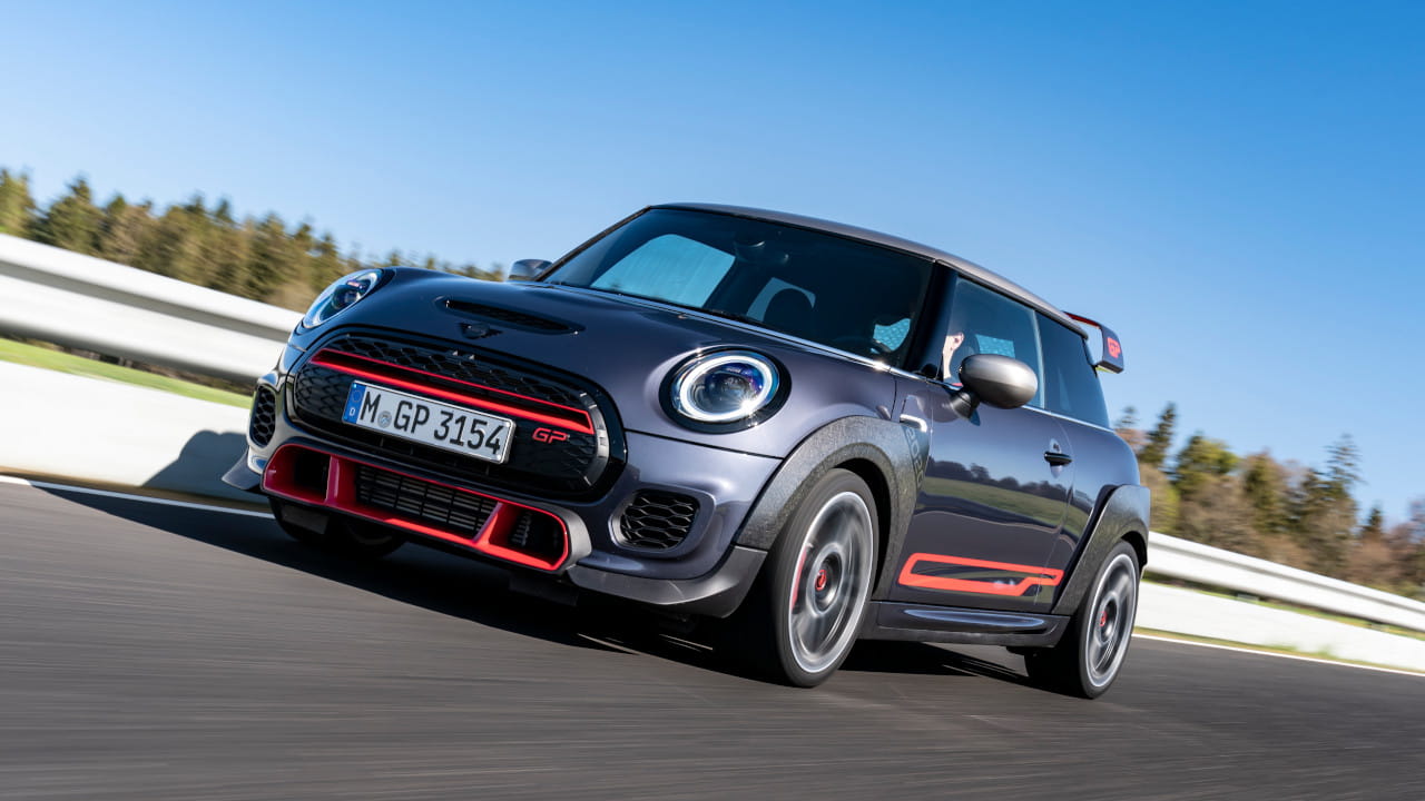Grey Mini John Cooper Works GP hot hatch with red accents driving on a race track