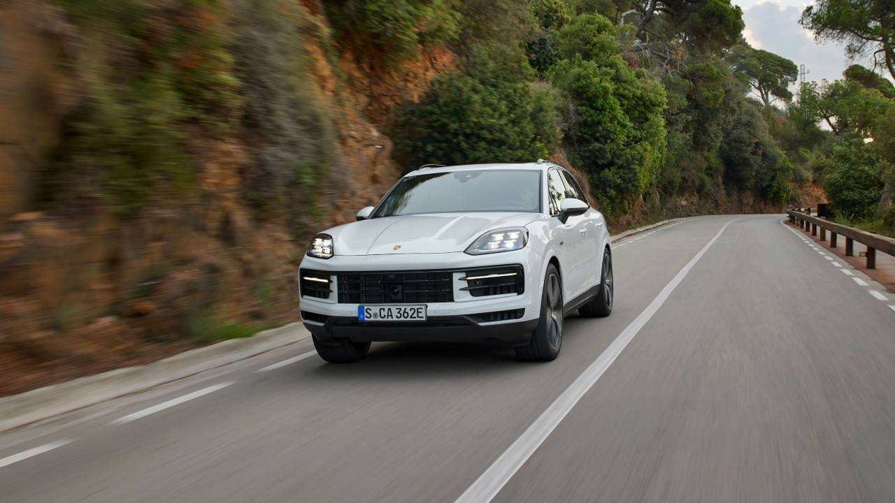 White Porsche Cayenne SUV driving on a winding road