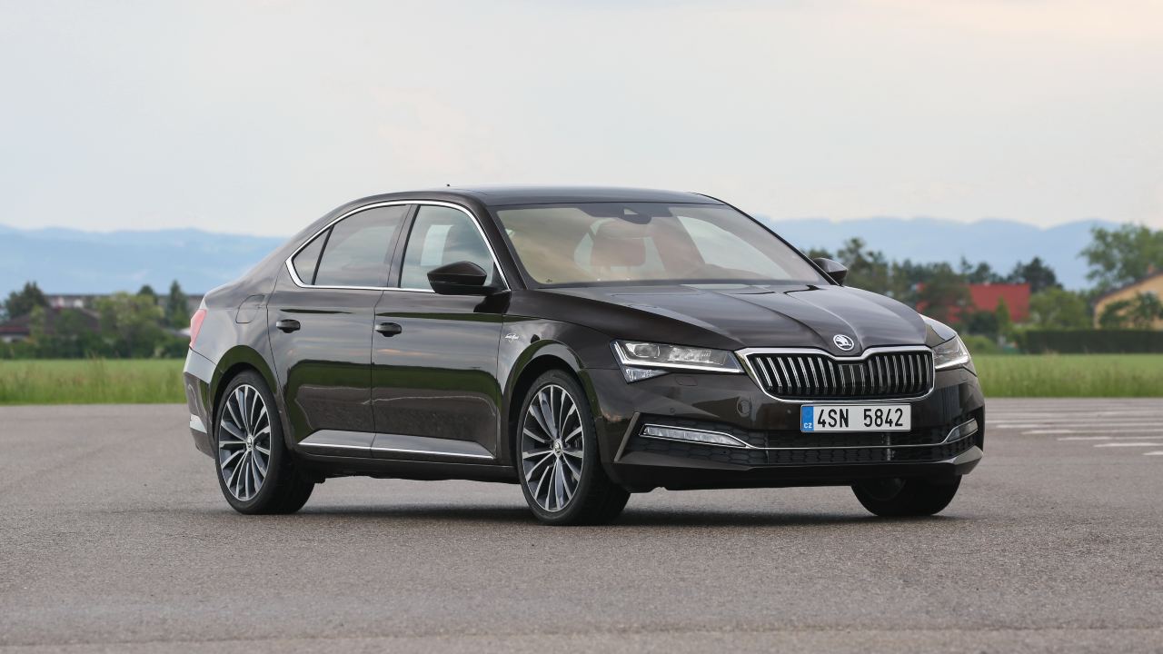 Black Škoda Superb saloon parked on an open test area