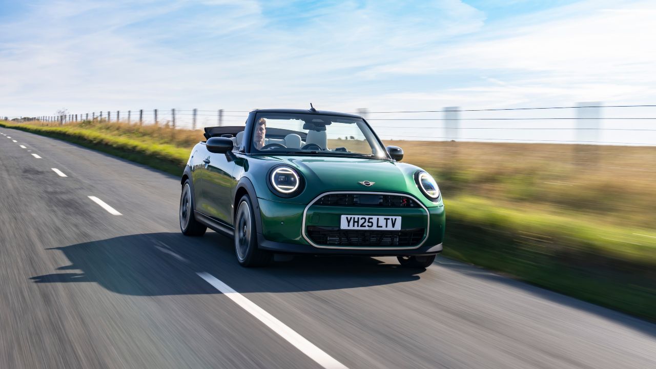 Green MINI Convertible driving with roof down