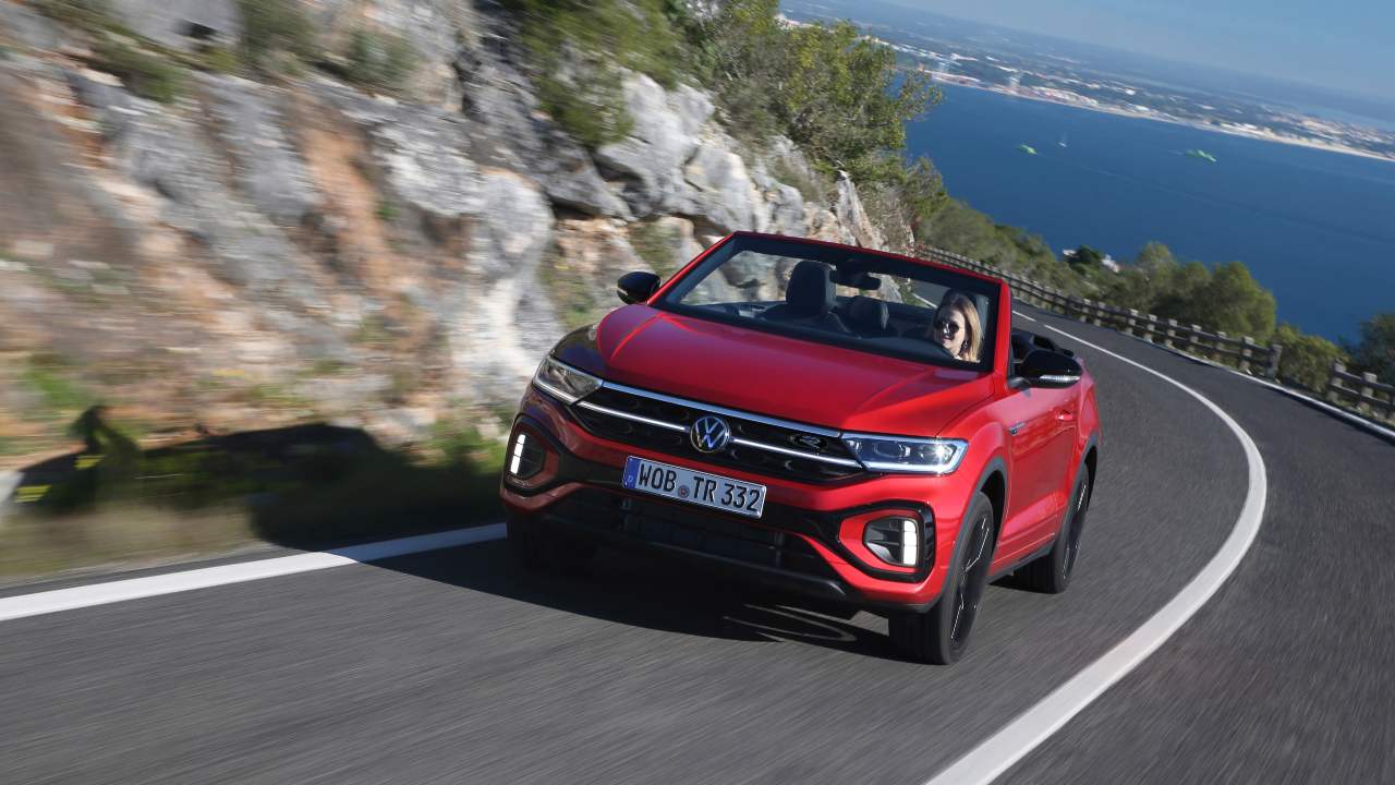 Red Convertible Volkswagen T-roc driving with roof down on scenic road