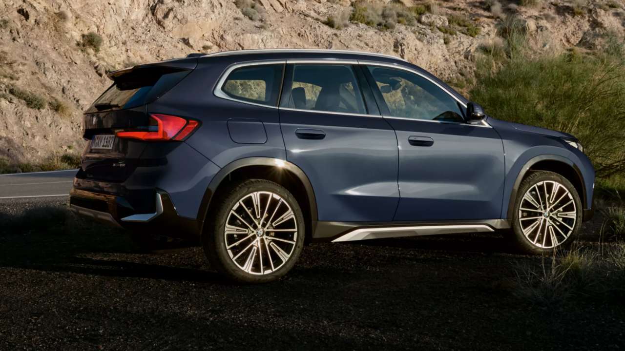 Blue BMW X1 sunset rear right angle