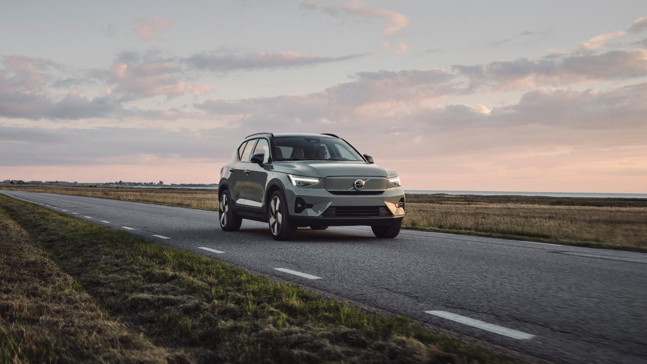 Green Volvo XC40 driving sunset