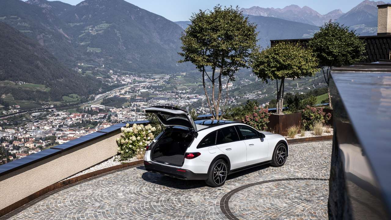 White Mercedes-Benz C-Class Estate with boot open on mountain side