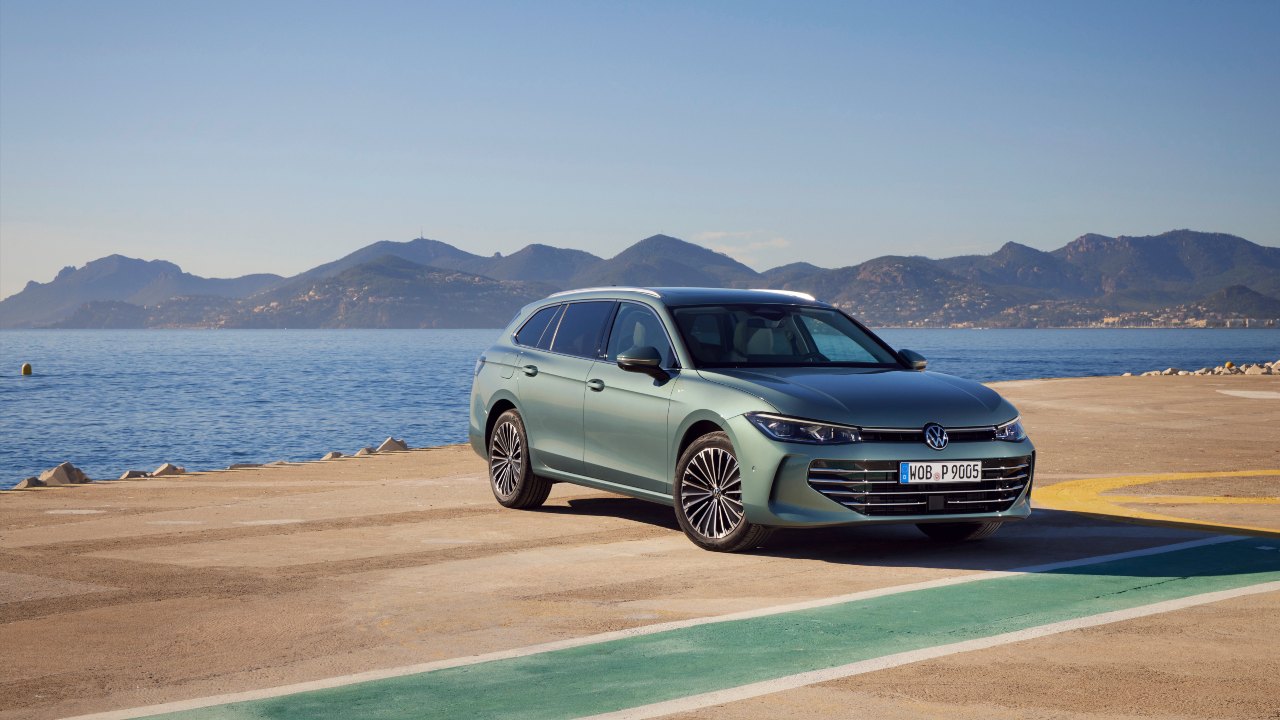 Green Volkswagen Passat static near the ocean