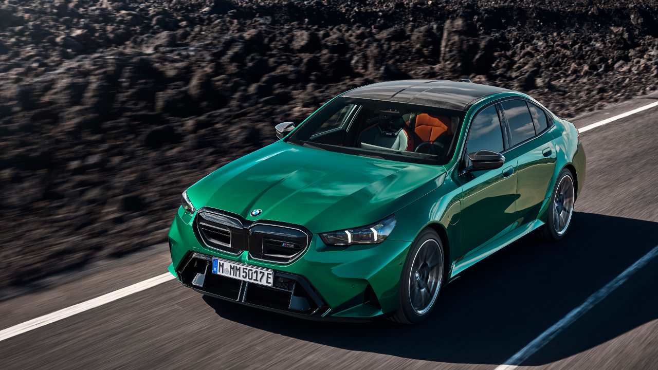 BMW M5 saloon driving on mountain road, front three-quarter view