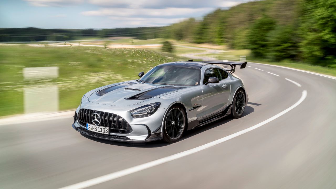 Mercedes-AMG GT Black Series driving on open road, grey coupe with large rear wing