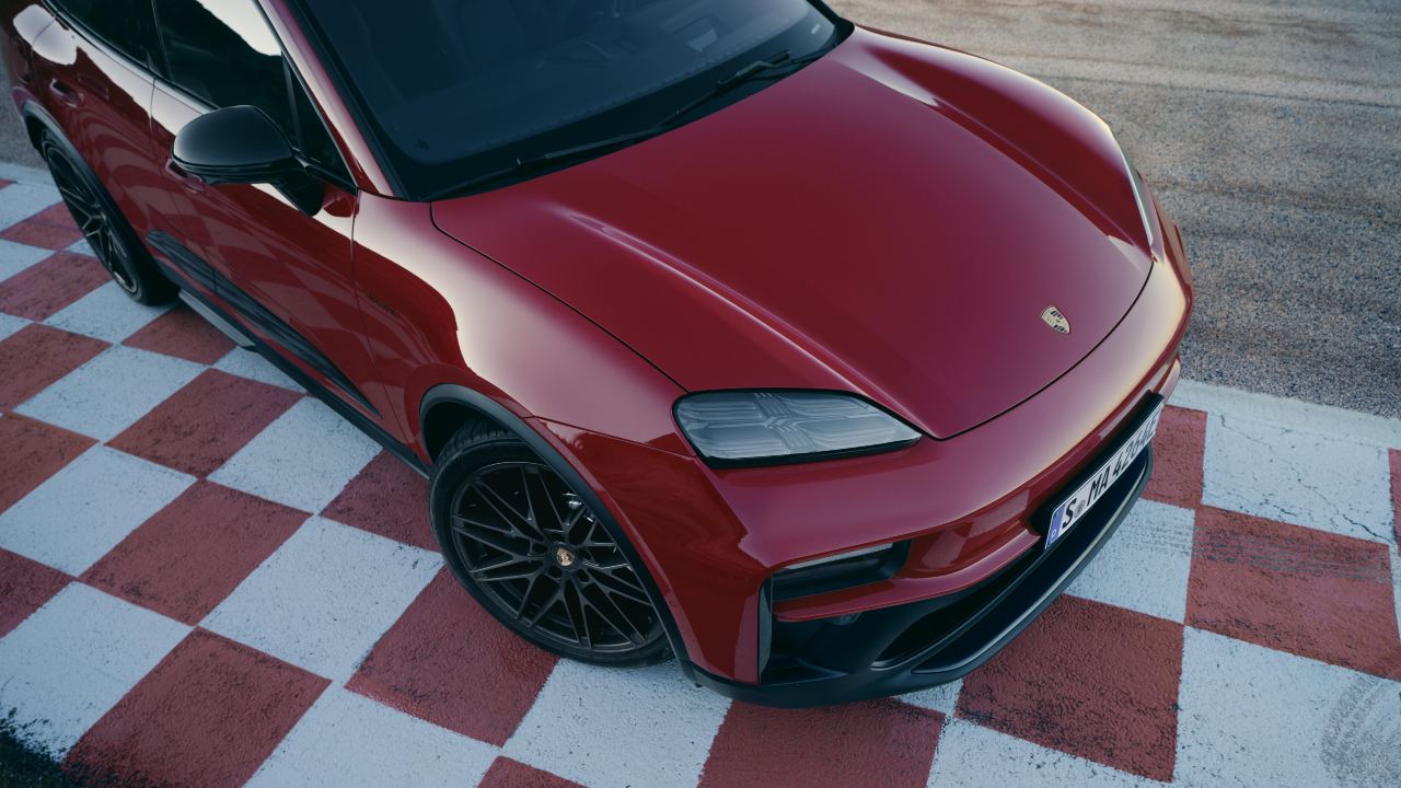Porsche Macan Electric close-up showing front design on a racetrack surface