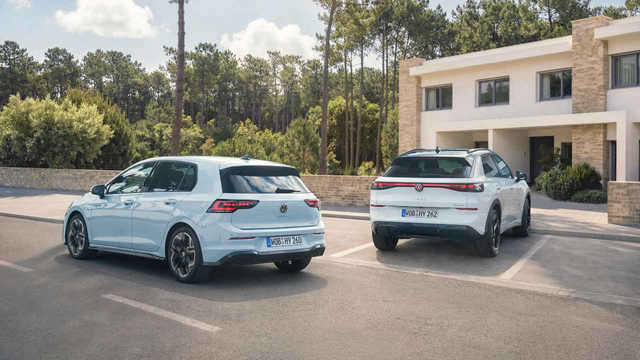 Volkswagen Golf and T-Roc parked side by side outside a modern home, rear view