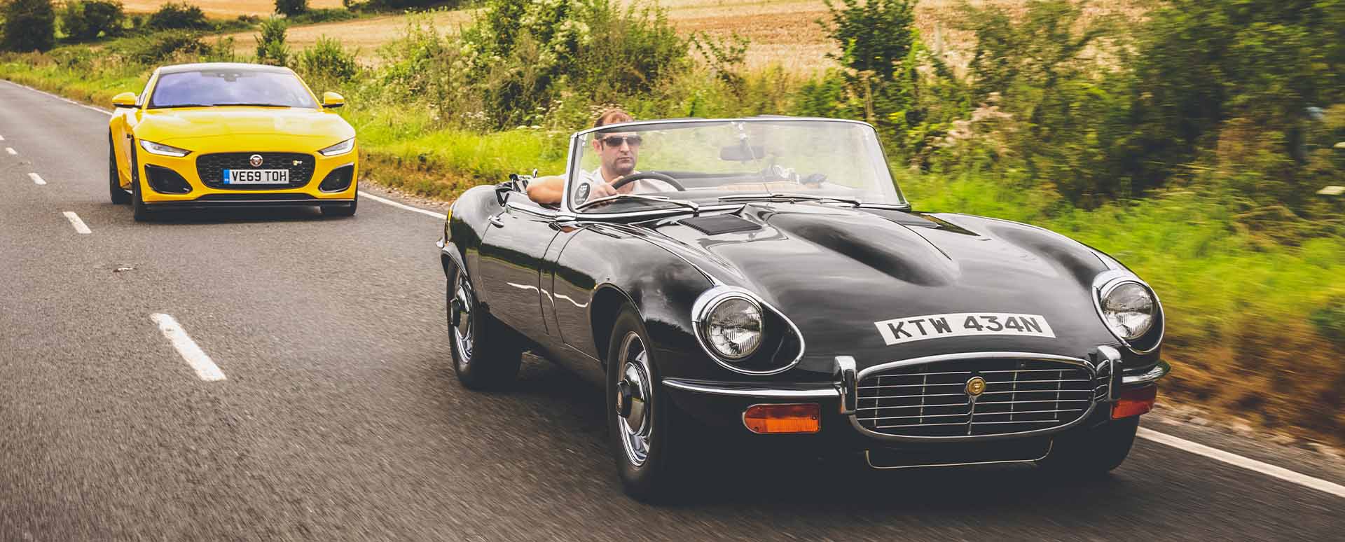 Yellow F-TYPE and Black E-Type Driving on Country Road