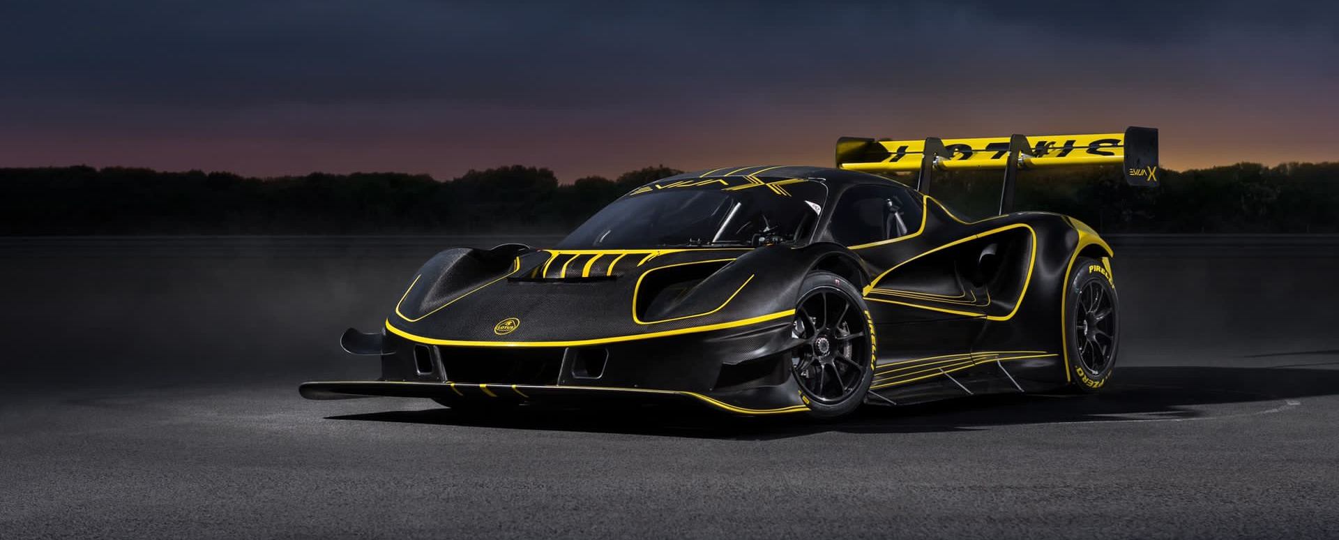 Lotus Evija X electric hypercar front three-quarter view with black and gold livery at sunset track setting