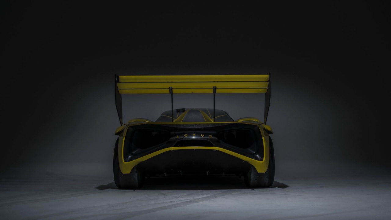 Lotus Evija X rear view with large rear wing, diffuser and distinctive LED lighting in dark studio setting