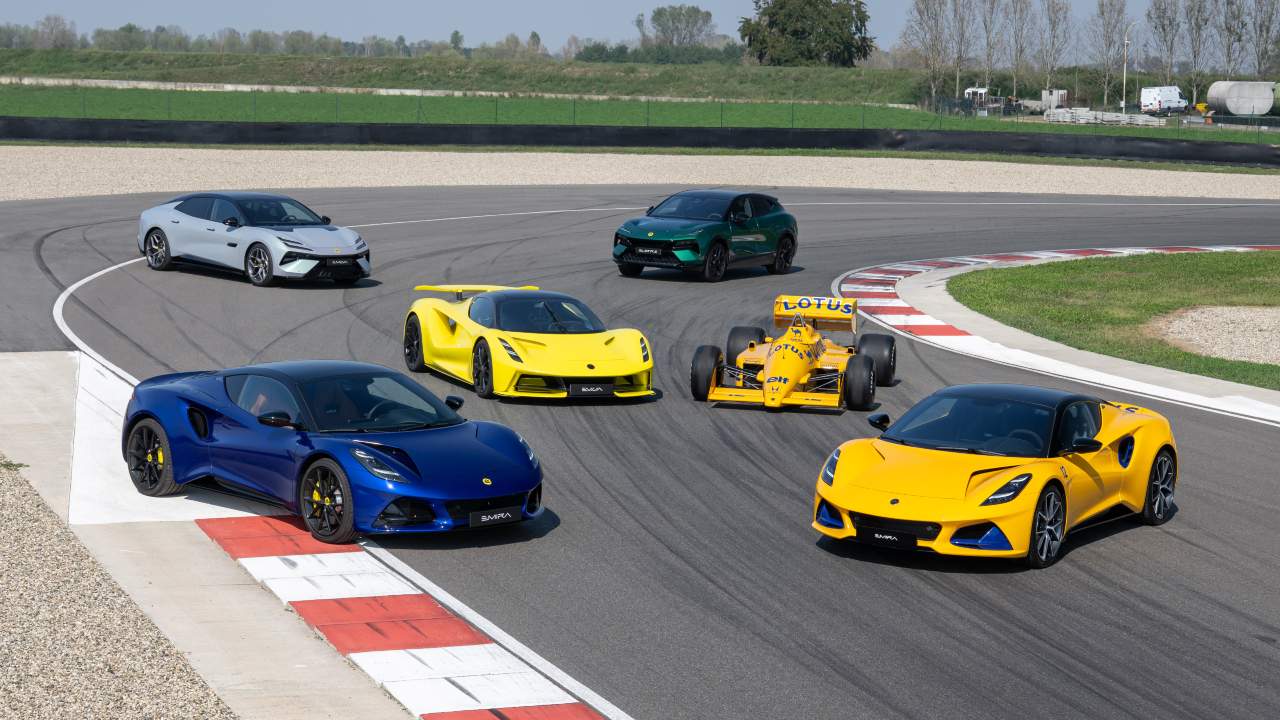 Lotus sports car lineup on racetrack including Emira, Evija, Eletre SUV and classic Formula One car