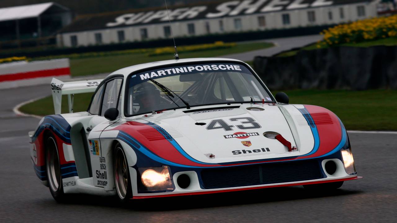 Porsche 935 close-up on racetrack with Martini livery, highlighting front-end design