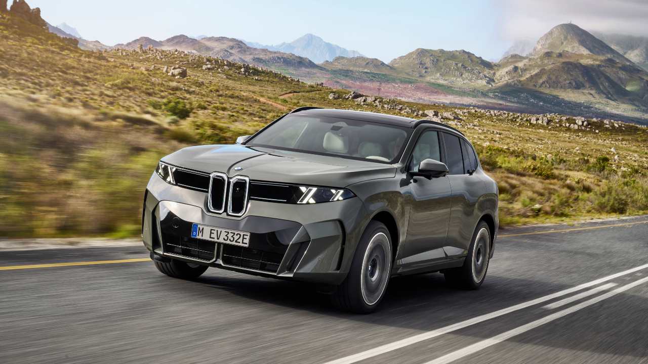 Grey BMW X5 driving through a mountainous landscape with rugged terrain in the background