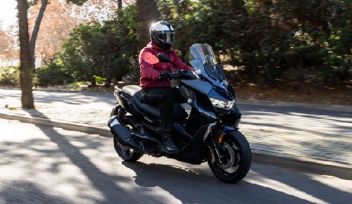 Motorcyclist Riding BMW Motorrad CE 400 GT Through Town