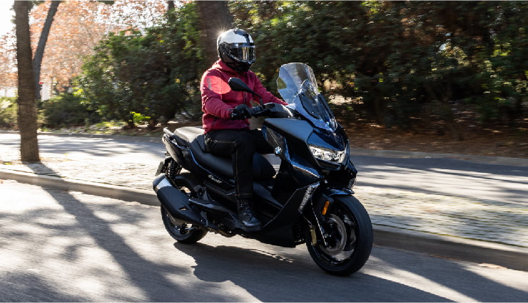 Motorcyclist Riding BMW Motorrad CE 400 GT Through Town