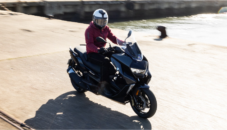 Motorcyclist Riding BMW Motorrad CE 400 GT Through Town